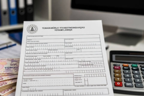 İŞKUR binası önünde bekleyen kişi, hesap makinesi, Türk Lirası ve işsizlik ödeneği başvuru formu.